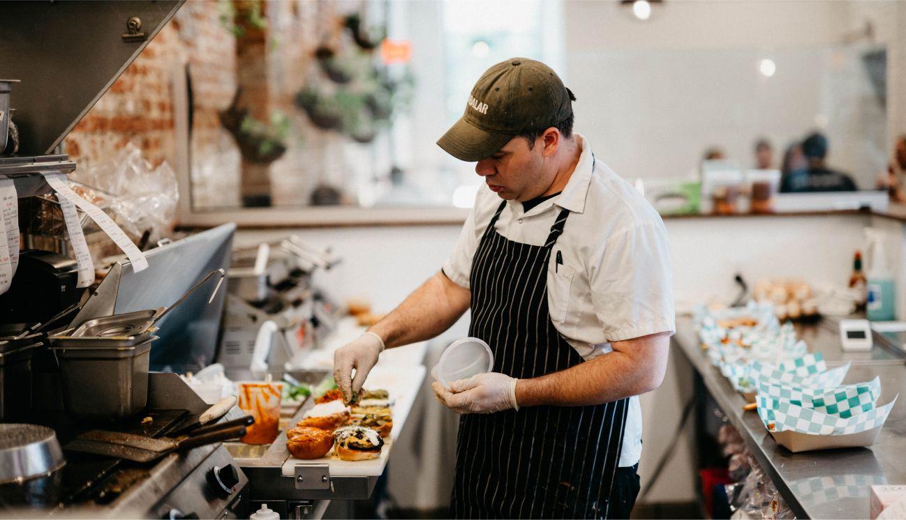 Chef preparing sandwiches and burgers.